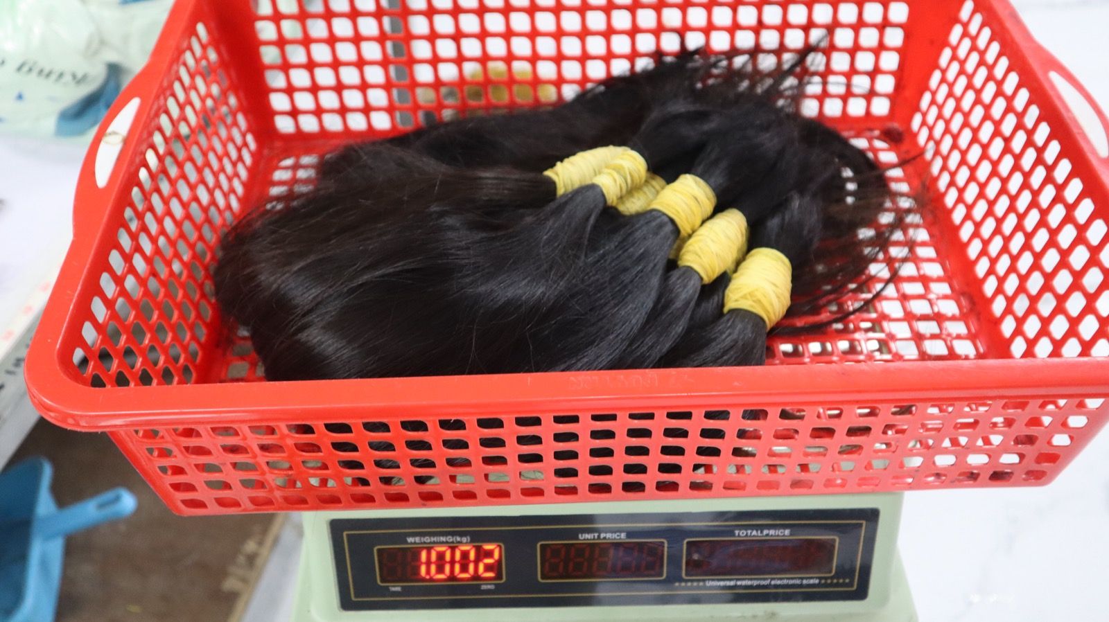 Hair bundles bagged by length in a shipping carton, with a packing list showing color, drawn level, length and weight